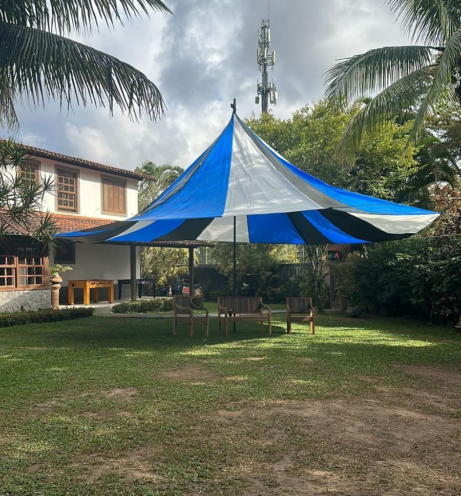 Tenda chapéu de bruxa azul e branca montada em jardim